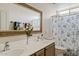 Bathroom with a large mirror, dual sinks, and a flower-patterned shower curtain at 1619 E Beretta Pl, Chandler, AZ 85286