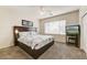 Comfortable bedroom featuring a king-size bed, plush carpeting, and a large window for natural light at 1635 W Owens Way, Anthem, AZ 85086