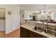 Modern kitchen featuring stainless steel sink, light countertops, and seamless flow into the living area at 1635 W Owens Way, Anthem, AZ 85086