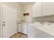 Well-lit laundry room with washer, dryer, utility sink, and storage cabinets at 1635 W Owens Way, Anthem, AZ 85086