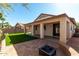 Inviting backyard with a covered patio, synthetic lawn, stone pavers, and fire pit at 16848 W Bradford Way, Surprise, AZ 85374