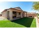 Attractive backyard with an outdoor patio, lush synthetic lawn, and block fencing at 16848 W Bradford Way, Surprise, AZ 85374