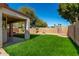Spacious backyard with a covered patio, lush synthetic lawn, and desert landscaping at 16848 W Bradford Way, Surprise, AZ 85374