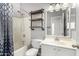 Well-lit bathroom with a shower-tub, wooden shelving, and white single sink vanity at 16848 W Bradford Way, Surprise, AZ 85374