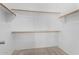 Walk-in closet with neutral carpet and built-in shelving and wood clothes rods at 16848 W Bradford Way, Surprise, AZ 85374