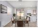 Dining room features a long table with seating for six, adjacent to the open-plan kitchen and backyard access at 16848 W Bradford Way, Surprise, AZ 85374