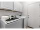 Bright laundry room with front loading washer and dryer and ample cabinet space at 16848 W Bradford Way, Surprise, AZ 85374
