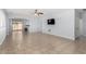 Open-concept living room features tile floors, neutral colors, and access to the kitchen and backyard at 16848 W Bradford Way, Surprise, AZ 85374