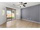 Open living room area with neutral tile flooring, a ceiling fan and sliding glass doors to the backyard at 16848 W Bradford Way, Surprise, AZ 85374