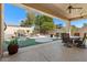 Inviting covered back patio overlooking a lush waterfall, perfect for outdoor dining and relaxation at 1710 W Tonto Dr, Chandler, AZ 85248