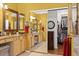 Bright bathroom featuring double sinks, granite countertop, mirrors, and walk-in closet with sliding doors at 17675 N Coconino Dr, Surprise, AZ 85374