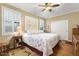Cozy bedroom featuring a ceiling fan and a large window for natural light at 17675 N Coconino Dr, Surprise, AZ 85374