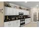 Well-appointed kitchen boasting white cabinets, stainless appliances, and ample counter space at 17675 N Coconino Dr, Surprise, AZ 85374