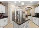 Bright kitchen featuring white cabinetry, granite counters, a stainless refrigerator, and a center island at 17675 N Coconino Dr, Surprise, AZ 85374
