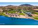 Aerial view of lakefront amenity, showcasing the sandy beach, tennis courts, and lush green space at 18344 W Santa Irene Dr, Goodyear, AZ 85338