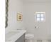 Bright bathroom features marble floors, white countertops, unique mirror and a neutral color palette at 18344 W Santa Irene Dr, Goodyear, AZ 85338
