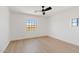 A minimalistic bedroom with wood floors and a modern ceiling fan at 18344 W Santa Irene Dr, Goodyear, AZ 85338