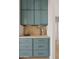 Charming butler's pantry featuring teal cabinets, elegant hardware, and a light marble backsplash at 18344 W Santa Irene Dr, Goodyear, AZ 85338