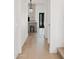 Hallway view featuring wood floors leading to a kitchen and front door at 18344 W Santa Irene Dr, Goodyear, AZ 85338
