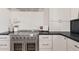 Close-up of a kitchen with a stainless steel oven and white cabinets against a textured backsplash at 18344 W Santa Irene Dr, Goodyear, AZ 85338