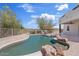 Backyard features a unique pool design, beautiful landscaping, and a desert view at 18344 W Santa Irene Dr, Goodyear, AZ 85338