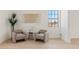Cozy sitting area with comfortable armchairs, minimalist decor, and natural light from the window at 18344 W Santa Irene Dr, Goodyear, AZ 85338