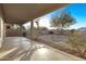 Covered back patio with a concrete floor overlooking a spacious yard and block wall fence at 22500 N Greenland Park Dr, Maricopa, AZ 85139