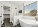 Modern bathroom featuring a soaking tub, tiled shower, and a large window with outdoor views at 22500 N Greenland Park Dr, Maricopa, AZ 85139