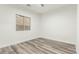 Well lit bedroom with gray wood-look floors, white walls, and a window overlooking the backyard at 22500 N Greenland Park Dr, Maricopa, AZ 85139