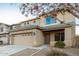 Two-story home boasting a wide driveway and desert landscaping, with a welcoming facade and spacious garage at 22500 N Greenland Park Dr, Maricopa, AZ 85139