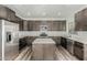 Kitchen features a stainless steel refrigerator, center island, and plenty of cabinet storage at 22500 N Greenland Park Dr, Maricopa, AZ 85139