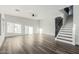 Bright, open-concept living room with modern gray floors and staircase at 22500 N Greenland Park Dr, Maricopa, AZ 85139