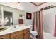 Neutral toned bathroom with a framed mirror, cherry toned cabinets, and a shower-tub combo at 2600 E Springfield Pl # 61, Chandler, AZ 85286