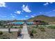 Community pool with red lounge chairs with mountain views on a sunny day at 32553 N 133Rd Ave, Peoria, AZ 85383