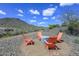 Cozy outdoor fire pit surrounded by four chairs, nestled in the desert landscape at 32553 N 133Rd Ave, Peoria, AZ 85383