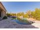 Backyard pool with rock features and lush landscaping at 37267 Ne Greythorn Cir, Carefree, AZ 85377