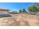 Large backyard with a covered patio and block fence ready for landscaping and outdoor activities at 3728 E Grove Ave, Mesa, AZ 85206
