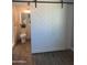 Stylish barn door concealing a well-lit bathroom with modern fixtures and wood-look flooring at 3728 E Grove Ave, Mesa, AZ 85206