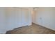 Bright bedroom featuring wood floors, closet, and a white painted door leading to the next room at 3728 E Grove Ave, Mesa, AZ 85206
