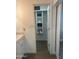 Bright closet with shelving, attached to a bathroom with a marble countertop and white cabinets with brushed metal knobs at 3728 E Grove Ave, Mesa, AZ 85206