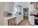 Modern kitchen featuring stainless steel appliances, white cabinetry, a center island, and wood-look flooring for a clean look at 3728 E Grove Ave, Mesa, AZ 85206