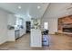 Open-concept kitchen with stainless steel appliances, central island, and wood-look flooring, flowing into the living area at 3728 E Grove Ave, Mesa, AZ 85206
