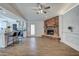 Open living area with a brick fireplace, wood floors, and a view into the kitchen at 3728 E Grove Ave, Mesa, AZ 85206