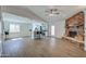 Spacious living room open to the kitchen with a brick fireplace and wood flooring at 3728 E Grove Ave, Mesa, AZ 85206