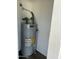 Image features an AO Smith 100 water heater inside a white closet space on a dark floor at 3728 E Grove Ave, Mesa, AZ 85206