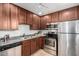 Functional kitchen with stainless steel appliances, dark cabinetry, and tiled floor offers practical cooking and cleaning at 4354 N 82Nd St # 183, Scottsdale, AZ 85251