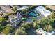 Expansive aerial view of a beautiful estate with a large pool, lush landscaping, and multiple buildings on the property at 5710 E Camelback Rd, Phoenix, AZ 85018