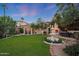 An expansive backyard featuring a beautiful fountain and an outdoor fireplace at 5710 E Camelback Rd, Phoenix, AZ 85018