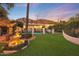 Beautiful backyard featuring a tiered fountain, green lawn, pool and mountain views at 5710 E Camelback Rd, Phoenix, AZ 85018