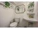 Quaint bathroom with white fixtures, open shelving, and unique gold-toned faucet and mirror at 5710 E Camelback Rd, Phoenix, AZ 85018